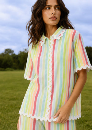
                  
                    Woman wearing a colorful striped dress in an outdoor setting
                  
                