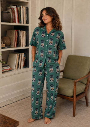 
                  
                    Woman with cat pajamas standing in a living room.
                  
                