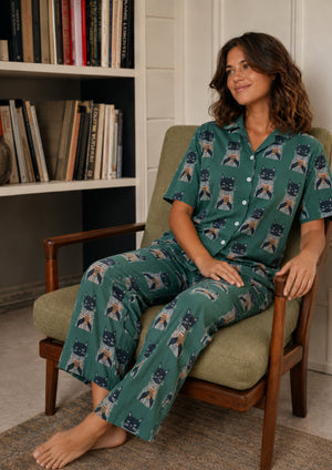 
                  
                    Woman with cat pajamas sitting on a chair.
                  
                