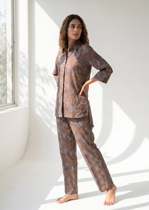 
                  
                    Woman wearing a patterned pajama set in a bright room with large windows.
                  
                