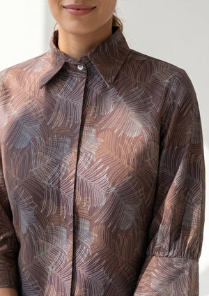 
                  
                    Close-up of a person wearing a patterned shirt with a neutral background
                  
                